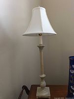 Full view of lamp on table showing base, column, and shade