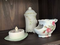 Three pieces on shelf: milk glass biscuit jar, shaving mug, butter dish