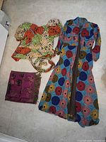 Long Ankara coat, matching wrap top and purple scarf laid flat on floor