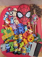 Overall view of entire mixed toy lot on red tray