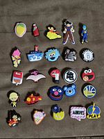 Full layout of 25 assorted shoe charms on fabric background
