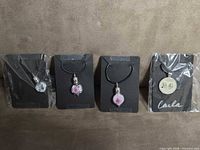 All four pendant necklaces on display cards