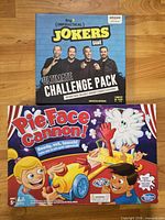 Front view of both game boxes: Impractical Jokers Ultimate Challenge Pack and Pie Face Cannon