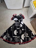 Dress laid flat showing entire pattern, red trim and flared skirt