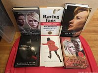 Front view of all six hardcover books upright showing titles and authors