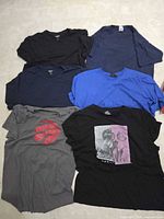 All six T-shirts laid flat showing colors and graphics
