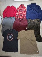 Overview of seven shirts laid out on floor