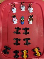 Overhead view of all 6 character figures on upper kart bodies plus 8 black and 2 yellow chassis parts