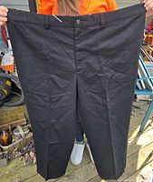 Front view of black dress pants showing flat front and waistband