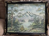 Full view of framed mountain landscape painting on couch