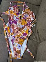 Front view of floral one-piece swimsuit showing colors, style, and straps