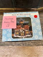 Front of box labelled Music Box/Boîte musicale with winter house image