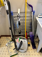 Group shot of vacuum, mops, rack and broom