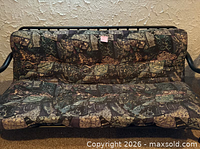 Front view of futon showing metal frame and patterned mattress