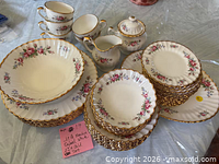 Full view of stacked plates, bowls, cups, creamer, sugar bowl