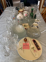 Overview of entire lot on table showing drinkware, teapots, platter and utensils