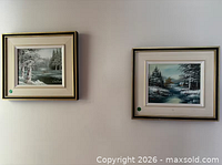 Two Cantrell winter landscape paintings framed on wall