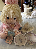 Group view of doll, plates, figurine, and gift box