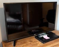 Front view of RCA TV on stand with Sony DVD player beneath