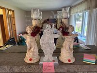 Front view of Santa stocking hanger flanked by two cherub candle holders
