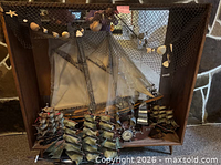 Full view of display case holding ship models, net and shells visible