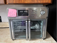 Front view of Kalorik stainless steel digital French-door toaster oven showing doors, controls, and interior rack