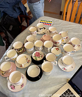 All teacups and saucers laid out on table