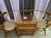 Full view of rattan table with glass top and two chairs