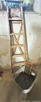 Ladder, washboard resting inside galvanized tub against wall