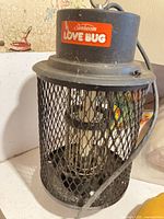 Front view of Sunbeam Love Bug bug zapper showing mesh body, light tube, cord, and branding label