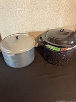 Both canning pots side by side with lids in place