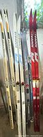 All four pairs of skis and poles leaning against wall