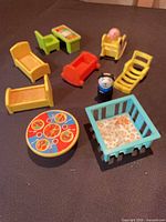All Fisher-Price dollhouse furniture pieces and figures arranged on surface