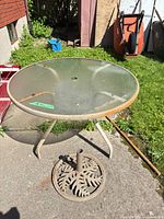 Full view of glass patio table and umbrella base