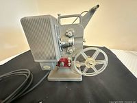 Left side view of Kodak Kodascope Eight-33 projector with reel and power cord visible