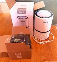 Air purifier with power cord, retail box, open box containing replacement filters