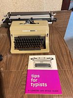 Beige Olivetti Linea 88 typewriter with guide book in front