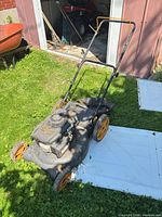Full view of mower showing handle, body, wheels