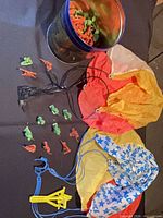 Overall lot showing two nylon parachutes, tin with toy soldiers, several soldiers outside tin