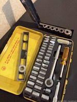Open yellow case with 40-piece socket set, steel socket bar and torpedo level visible