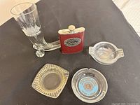 Group shot of beer boot, flask and three ashtrays