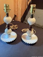 Pair of white hobnail milk glass table lamps side by side showing full form and cords