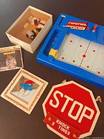 Overview showing Rocket Hockey game, View-Master sleeve, Smurf plaque, Stop sign plaque, Lego box