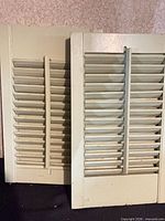 two overlapping wooden louvered shutter panels