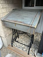 Front view of slant-top desk on treadle base