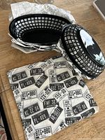 Stacks of black plastic diner baskets with printed liners visible