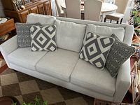 full front view of light grey sofa with four pillows