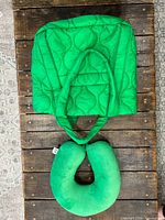 Front view of green quilted travel bag with neck pillow