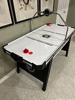Full view of NHL air hockey table with scoreboard, strikers, puck