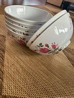 Stack of white bowls showing exterior floral design